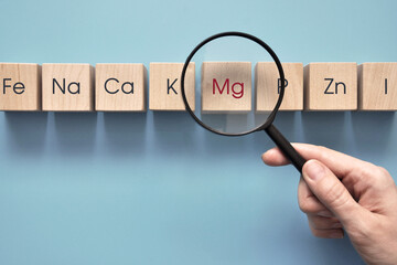 Wooden cubes with inscriptions of vitamins and macronutrients. Choosing magnesium from other useful substances
