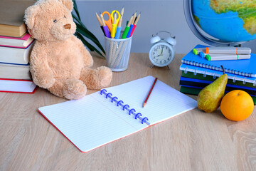 student home office table with white alarm clock, books, teddy bear, colored notebooks, pencils in glass, chalk board, globe, white alarm clock, concept of education, back to school, knowledge day