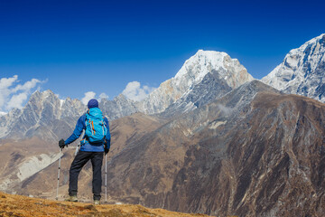 Fototapeta premium Active hiker hiking, enjoying the view, looking at Himalaya mountains landscape. Travel sport lifestyle concept