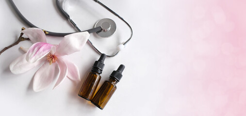 oil, tincture, medical stethoscope, creating a new medicine from plants, gifts of nature, dietary supplements, magnolia flowers, concept science, natural medicine, pharmacology, banner