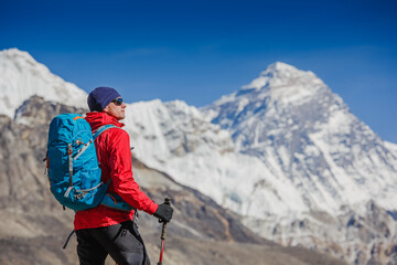 Fototapeta na wymiar Hiking in Himalaya mountains. Young man with backpack enjoying Everest view