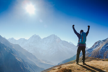 Hiker cheering elated and blissful with arms raised in the sky after hiking. Everest base camp trek