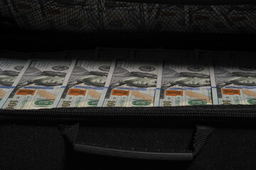 Fototapeta na wymiar The money's in the suitcase. U.S. dollars cash in a suitcase
