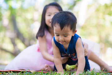 Group of happy preschool boy and girl playing in city park