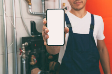 White blank screen on phone in plumber's hand in protection gloves. mockup for house repair or building or installing heating system