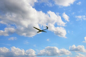 Sailplane, glider in the white clouds blue sky