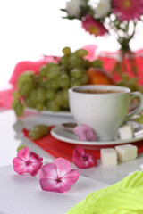 Morning breakfast with coffee, flowers and fruits on a light background