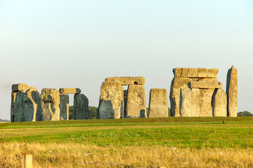Famous standing stones of Stonehenge in Wiltshire, England. Sunlight, Clear sky, green grass, no...