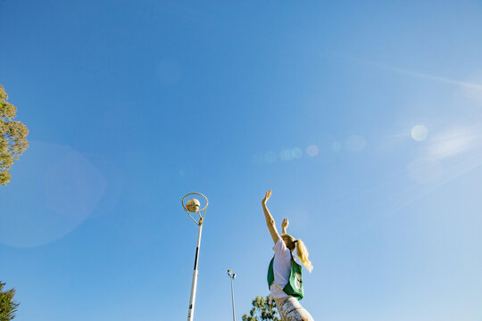 horizontal shot of a young woman celebrating after scoring in a net ball game