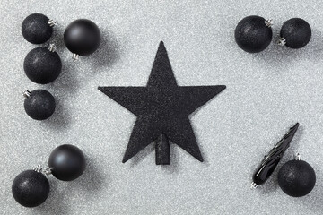 Black Christmas toys or decor on a gray background with copy space
