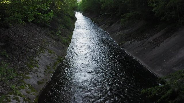 Drone view of an artificial canal in a green forest