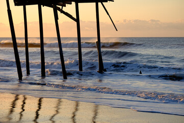 Storm battered broken down pier at sunrise on the Atlantic ocean off the North Carolina Coast