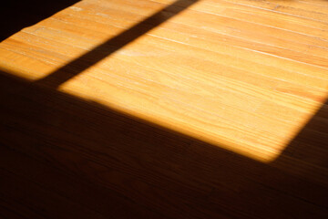 Sunlight and shadows fall on a freshly installed pine floor