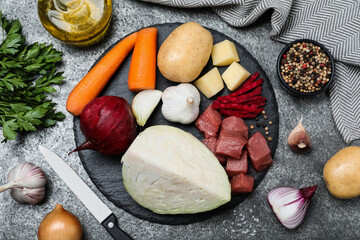 Ingredients for traditional borscht on grey table, flat lay