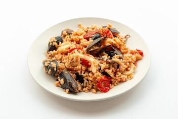 Seafood rice, typical Italian food. Served on a white background.