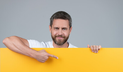 presenting novelty information. male behind yellow paper. for your marketing design.