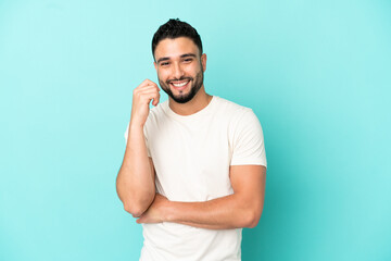 Young arab man isolated on blue background laughing