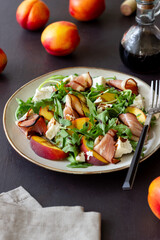 Salad with peaches, arugula, cheese and jamon. Healthy eating.