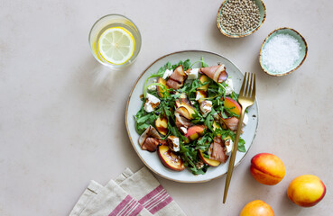Salad with peaches, arugula, cheese and jamon. Healthy eating.
