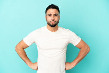 Young arab man isolated on blue background angry