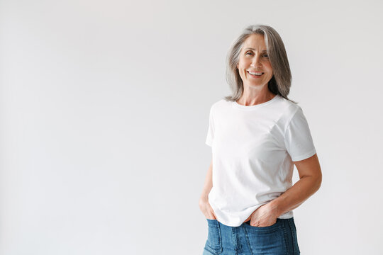 Grey senior woman in t-shirt smiling and looking at camera