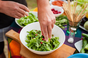 Preparation vegetable salad. Woman preparing food on table at backyard. Making vegetarian foodPreparation vegetable salad. Woman preparing food on table at backyard