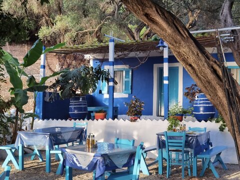 EDITORIAL: CORFU, GREECE, 4 AUGUST 2021, FISH TAVERN FISHERMAN IN SUNSET, corfu, greece, 4 august 2021, fish tavern fisherman in sunset tables fishes chairs in the yard by the sea