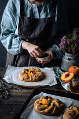 French galette with peaches, blackberries, mascarpone, natural honey and lavender on baking paper.