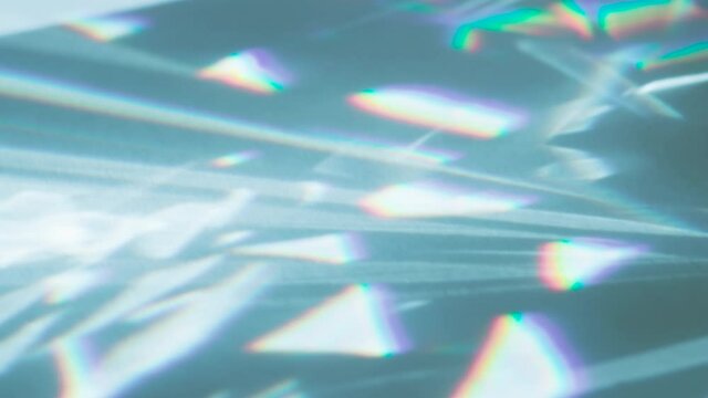 Focusing Refracted Rays. Loop. The optical lens system creates a series of bright, changing geometric highlights on a light surface