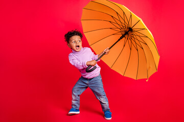Full length body size view of attractive cheerful schoolkid holding parasol having fun isolated...