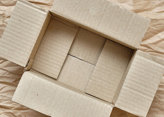 Top Down of Brown Paper Box Opened, Inside is Empty, Wrapping Brown Paper Background, Copy Space for Text and Graphic.