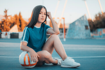 Chica jugadora profesional sentada con el balon posando en la pista de juego © Migue Suarez