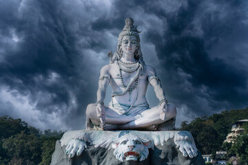 Statue of meditating Hindu god Shiva on the Ganges River at Rishikesh village in India
