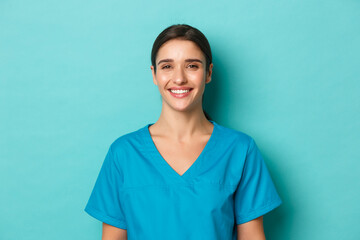 Coronavirus, social distancing and health concept. Close-up of young smiling female doctor, wearing...