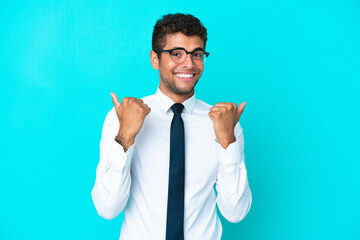 Young business Brazilian man isolated on blue background with thumbs up gesture and smiling