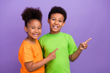 Photo of two young little afro kids happy smile point fingers empty space ads advise promo isolated...