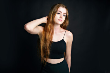 Fototapeta na wymiar Beautiful young redhead girl with attitude a portrait on black background