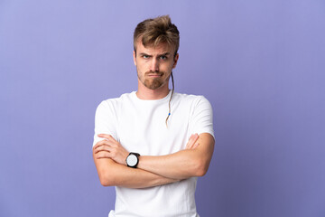 Young handsome blonde man isolated on purple background feeling upset