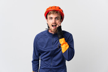Young cyclist blonde man isolated on white background with surprise and shocked facial expression