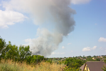 Fototapeta na wymiar a gray pillar of smoke on the horizon. fire in an open area.