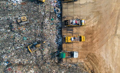 A lot of waste is disposed of in the waste disposal pits. Loaders is working on a mountain garbage. Aerial view and top view.