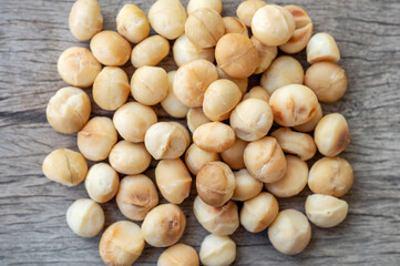 Pile of peeled Macadamia nuts on wooden table