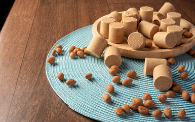 Peanut candy (paçoca or pacoca) Traditional Brazilian candy based on peanuts, and also peanuts laid out on a blue tablecloth. Selective Focus.