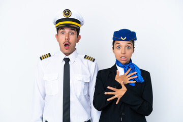 Airplane pilot and mixed race air hostess isolated on white background with surprise and shocked...