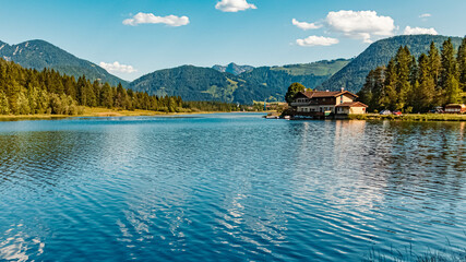 Fototapeta na wymiar Beautiful alpine summer view with reflections and the famous Jacob cross in the background at the famous Piller lake, Tyrol, Austria