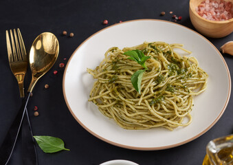 Pasta spaghetti with zucchini, basil, cream and cheese on black stone table. vegetarian vegetable pasta. zucchini noodles. top view copy space. penne pasta with pesto sauce, flat lay.