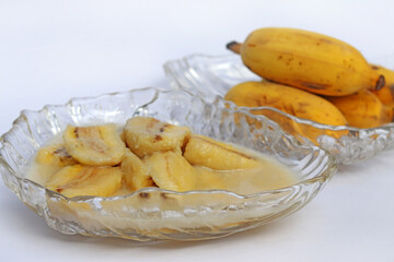 Homemade cultivated banana in coconut milk recipe on white background. One of popular traditional dessert of Thailand and Southeast Asia.