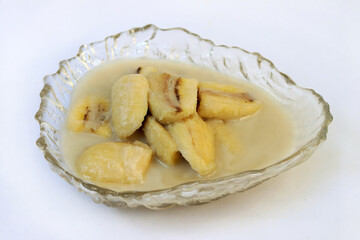 Homemade cultivated banana in coconut milk recipe on white background. One of popular traditional dessert of Thailand and Southeast Asia.