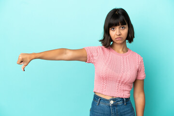 Young mixed race woman isolated on blue background showing thumb down with negative expression