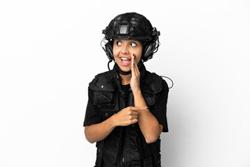 SWAT woman isolated on white background pointing to the side to present a product and whispering something